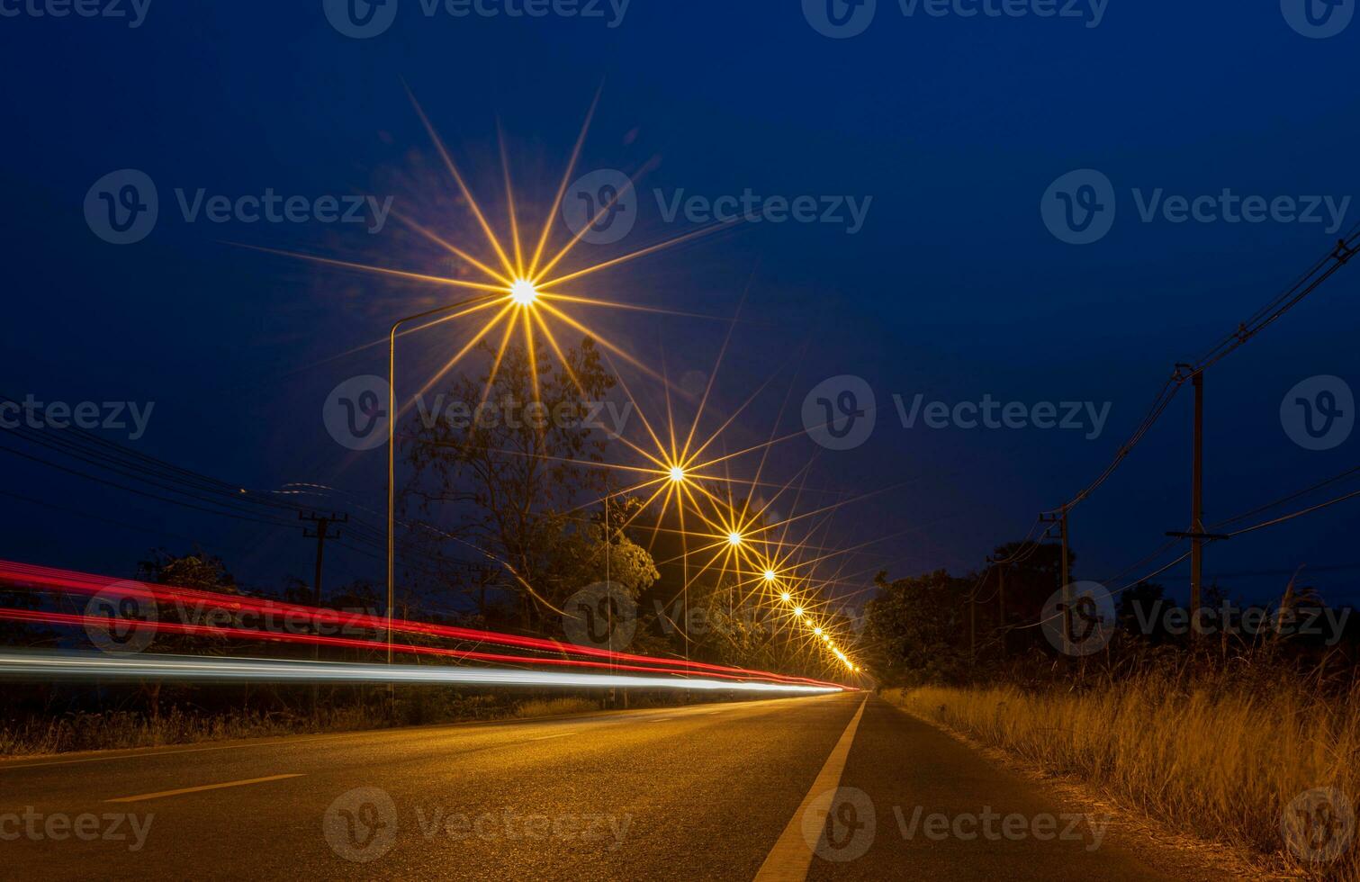 A view of orange starbursts from streetlights and car lights passing. photo