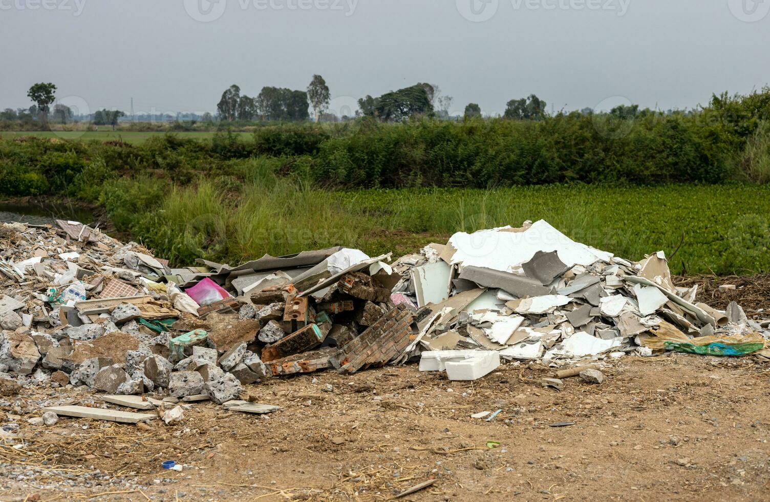 Scenery of piles of concrete debris and white tiled ceilings being dumped together. photo