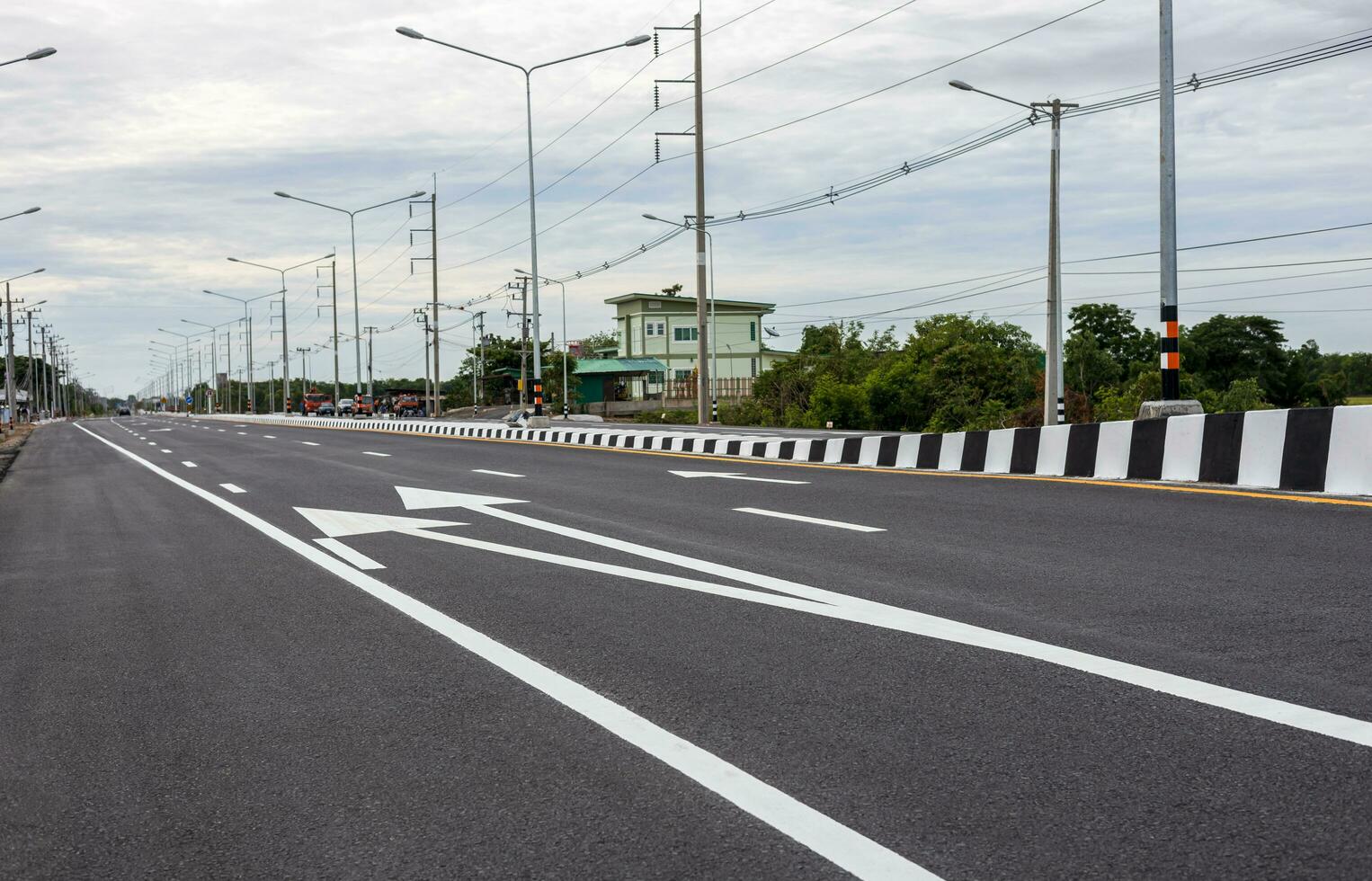 View of new asphalt road with white arrows and other symbols stretching. photo
