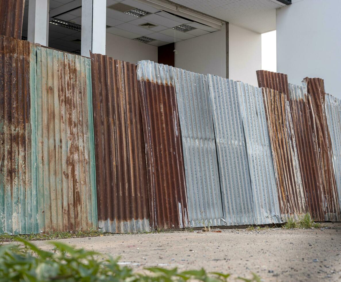 Low angle view of old galvanized sheet walls forming a wall on the ground. photo