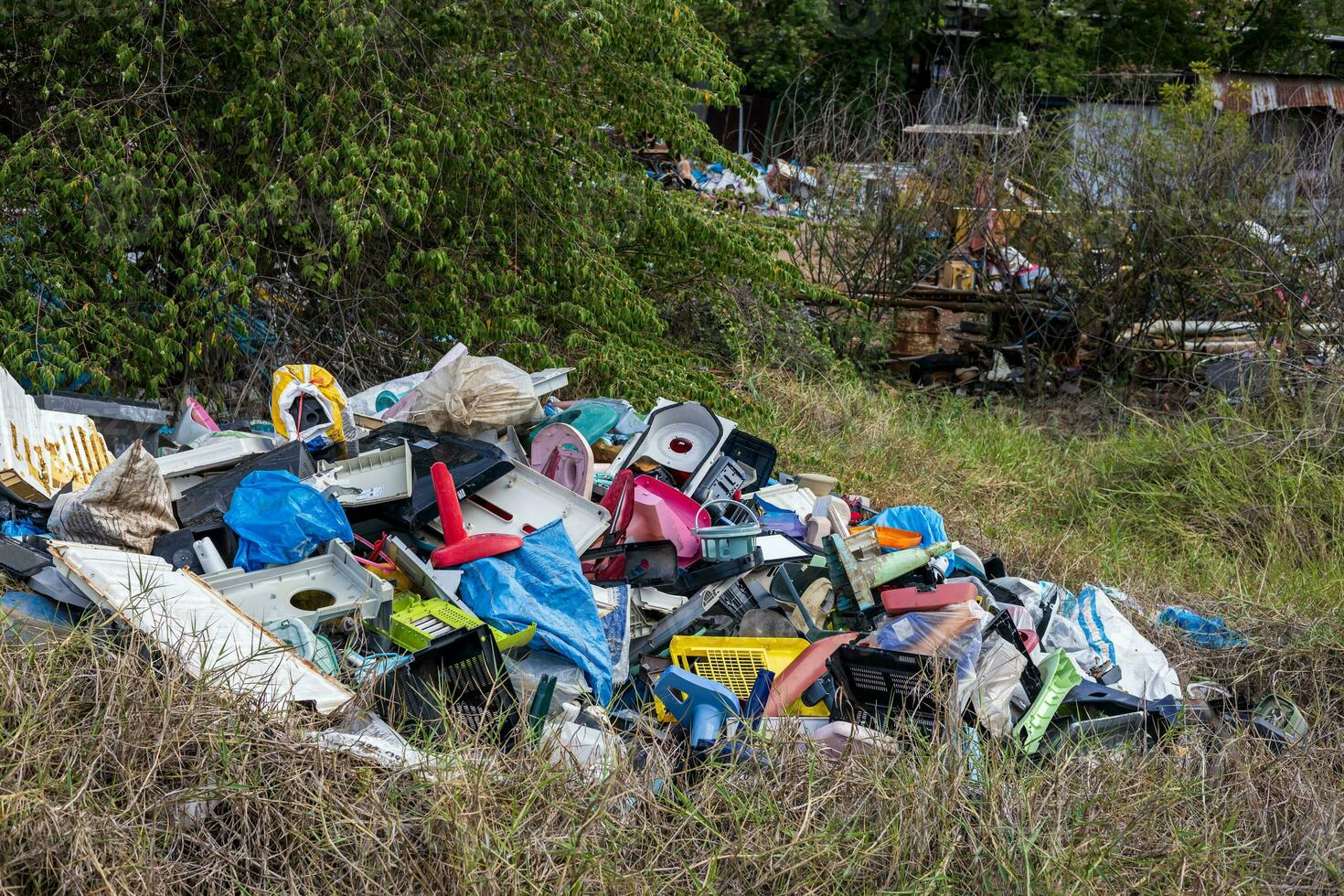 Views of all sorts of plastic debris from discarded gadgets piled up on the grass. photo