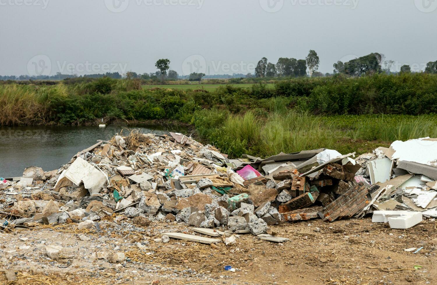 Scenery of piles of concrete debris and white tiled ceilings being dumped together. photo
