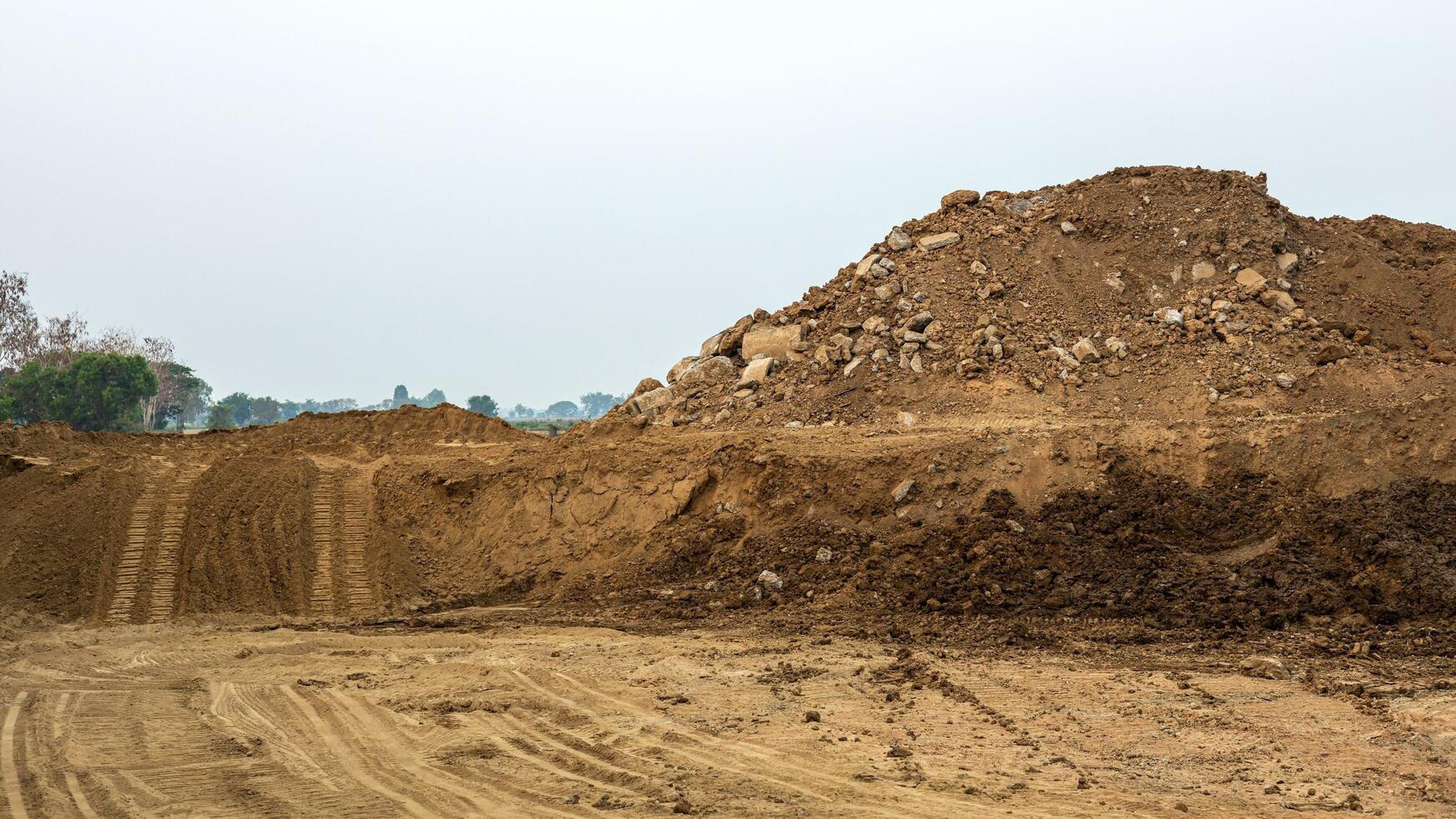 Scenery of a large mound of sand that was excavated and poured together leaving traces. photo