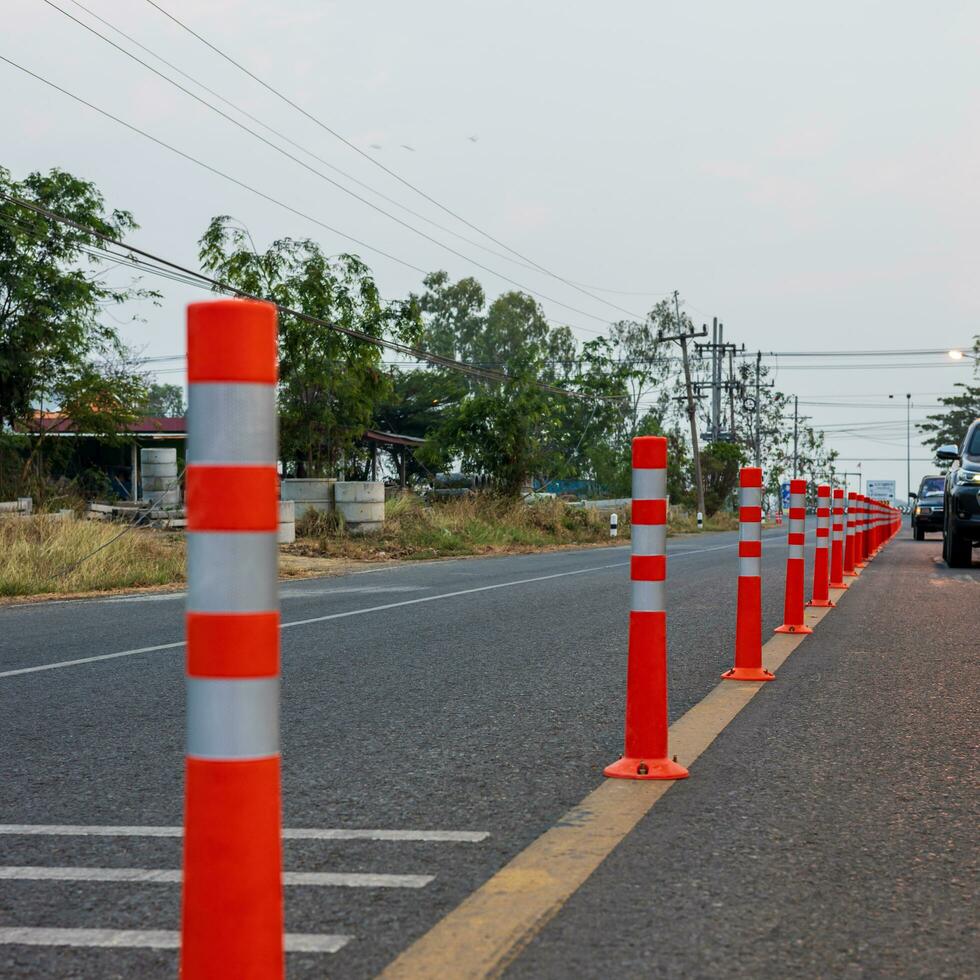 A low-angle view of many reflective orange plastic poles set up as a sign to prevent oncoming traffic. photo