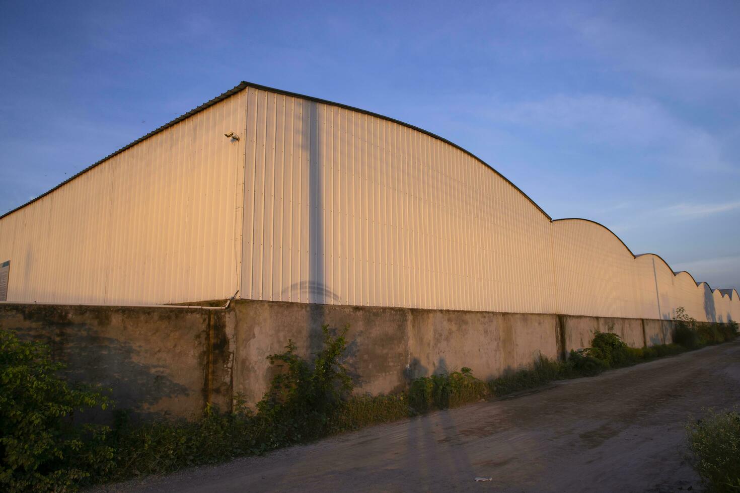 Industrial evening sunlight reflecting on the industrial warehouse  against the blue sky landscape view photo