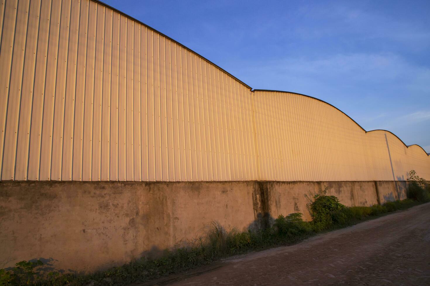 Industrial evening sunlight reflecting on the industrial warehouse  against the blue sky landscape view photo