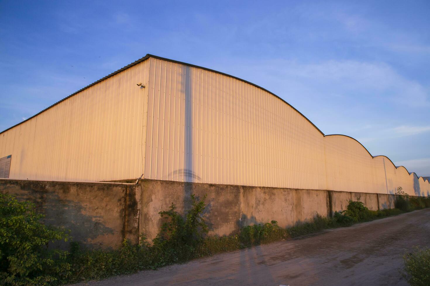 Industrial evening sunlight reflecting on the industrial warehouse  against the blue sky landscape view photo