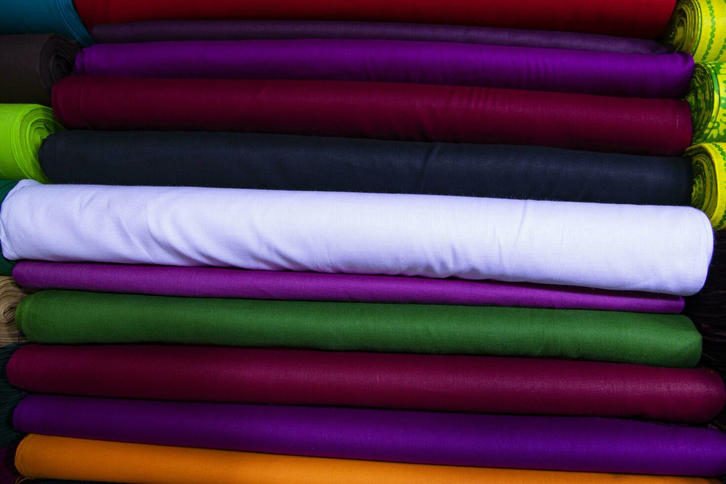 Artistic variety shade tone colors Textile Fabrics stacked on retail Shop Shelf to sale photo