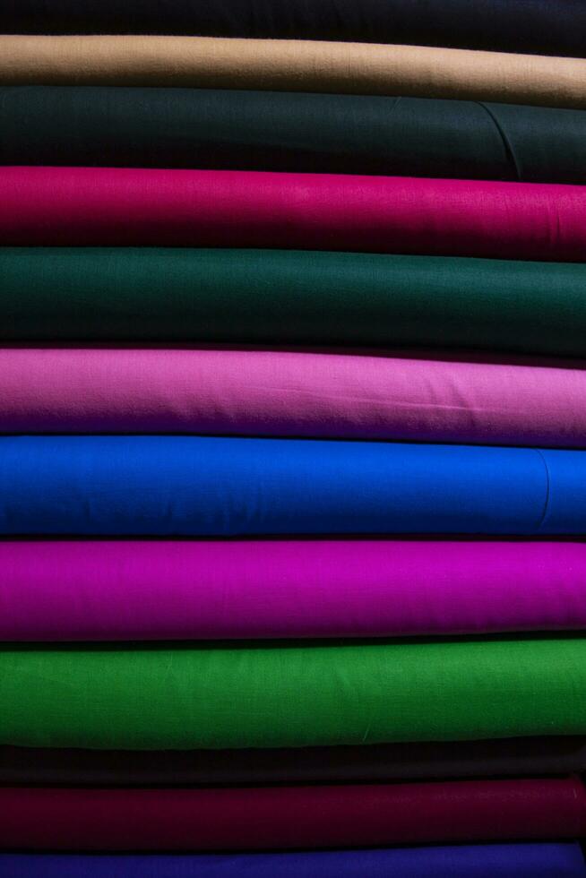 Artistic variety shade tone colors Textile Fabrics stacked on retail Shop Shelf to sale photo