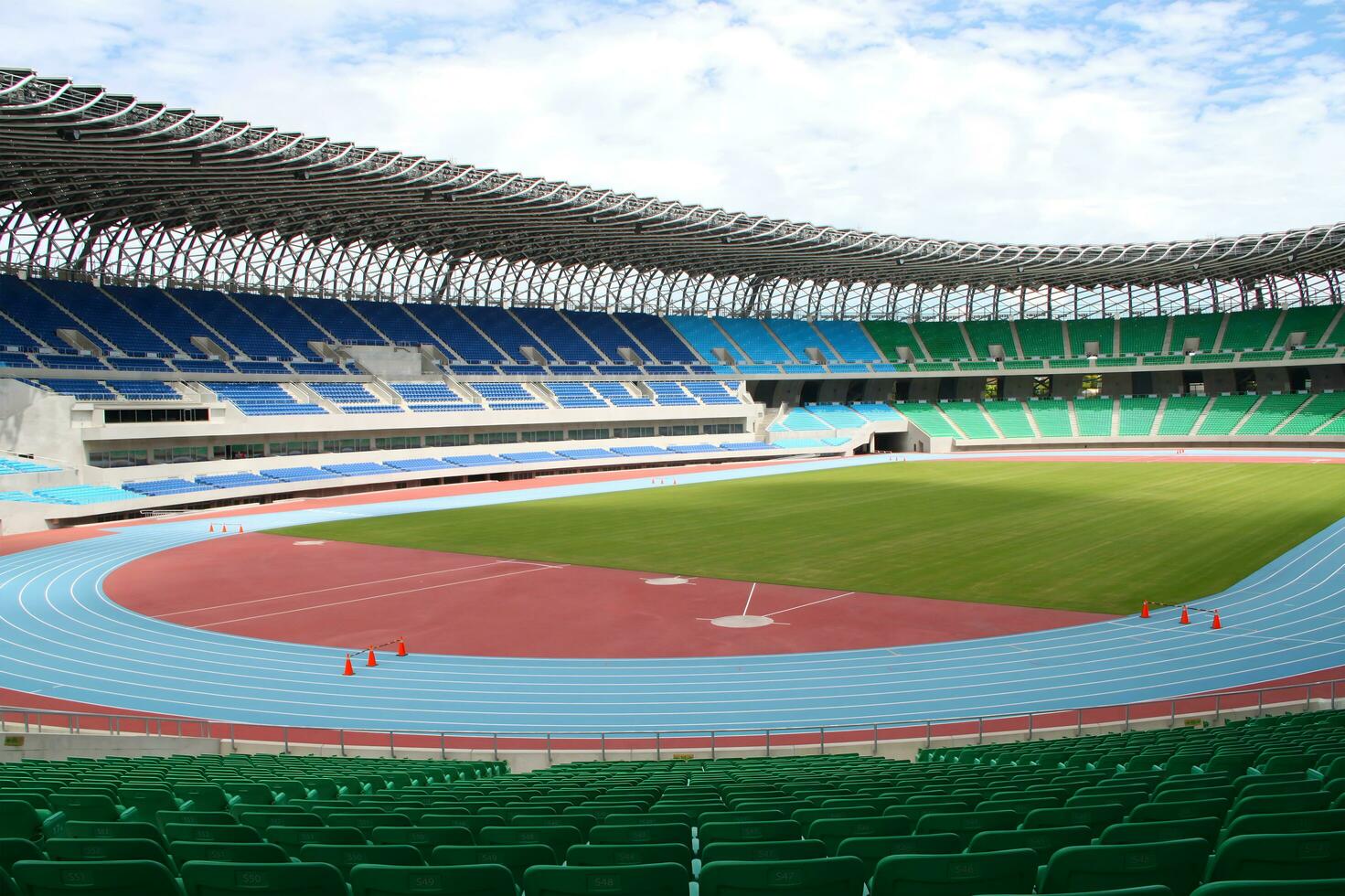 Rows of empty football stadium with green seats and blue sky in backgrounds for banners, posters, information graphics, prints layout covering books, magazine page, advertising material, advertisement photo