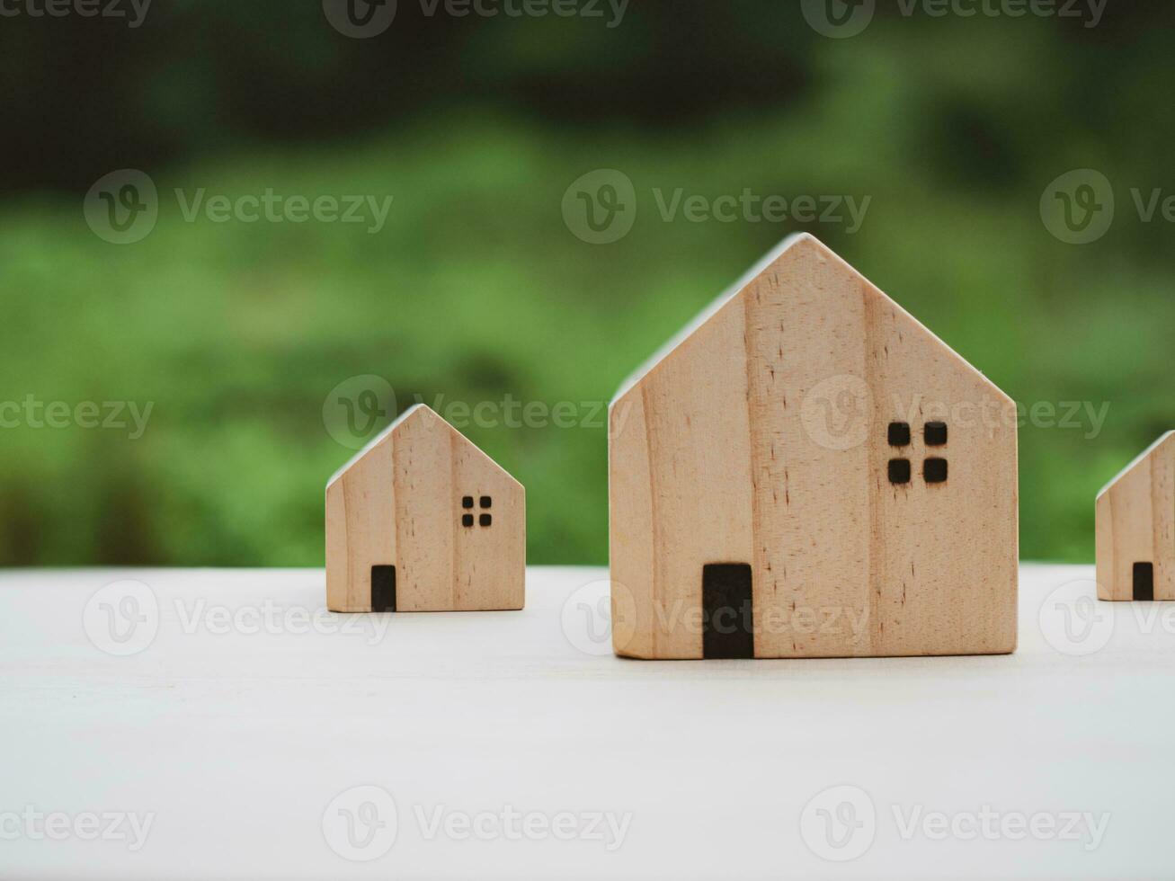 Concept of selling a house. Model house on a nature background. Real estate agent offer house, property insurance and security, affordable housing concepts, home insurance broker agent photo