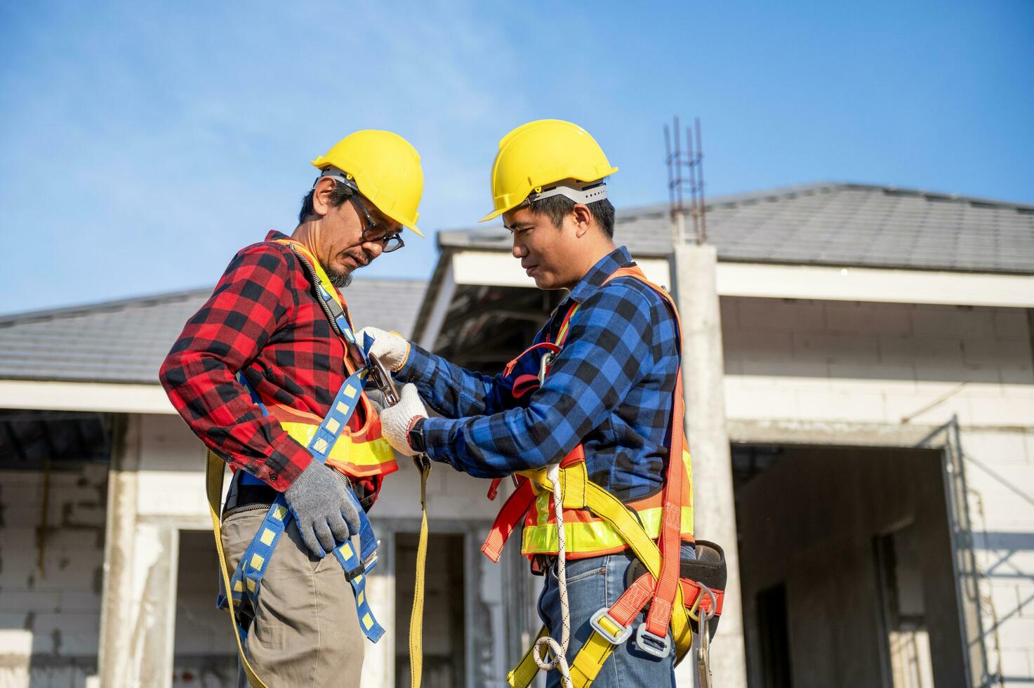 construcción trabajador preparando la seguridad en trabajo ropa antes de instalando nuevo techumbre herramientas techumbre herramientas, eléctrico simulacros y usado en nuevo de madera techos con metal hojas foto