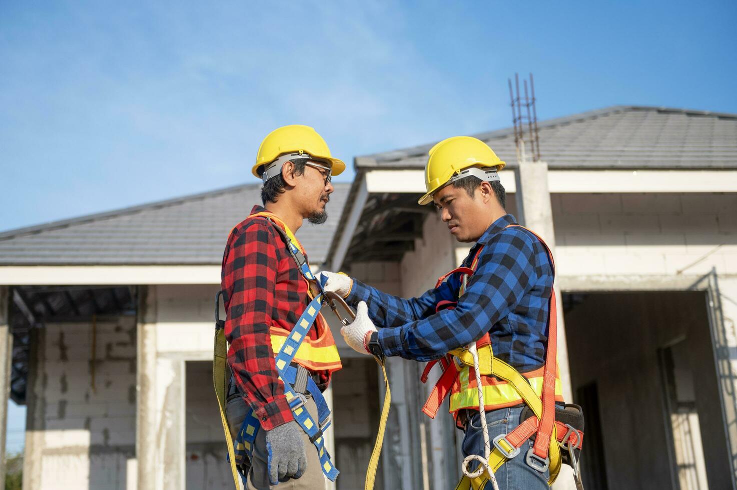 construcción trabajador preparando la seguridad en trabajo ropa antes de instalando nuevo techumbre herramientas techumbre herramientas, eléctrico simulacros y usado en nuevo de madera techos con metal hojas foto