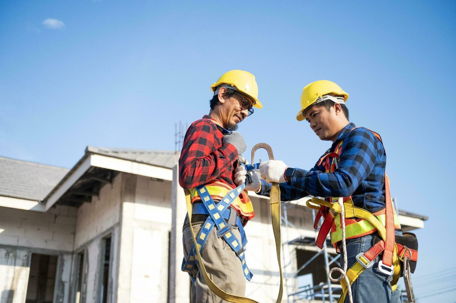 construcción trabajador preparando la seguridad en trabajo ropa antes de instalando nuevo techumbre herramientas techumbre herramientas, eléctrico simulacros y usado en nuevo de madera techos con metal hojas foto