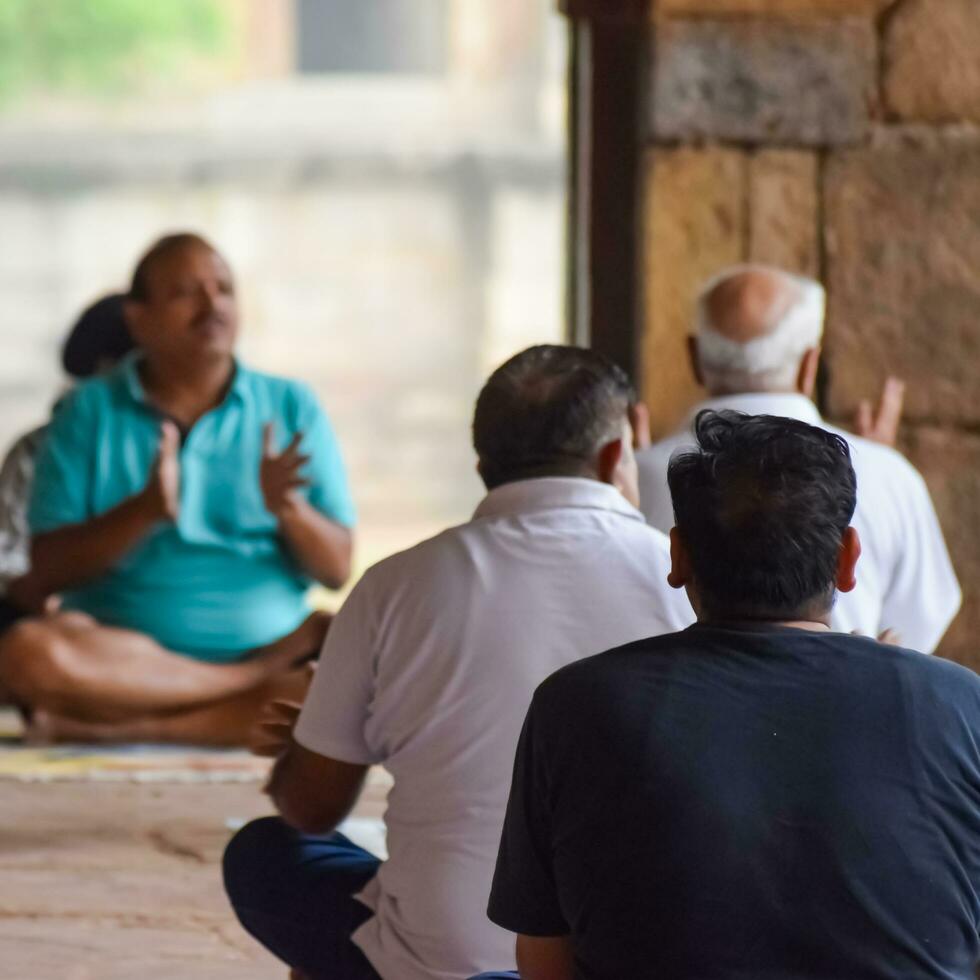 New Delhi, India, May 31 2023 - Group Yoga exercise class for people of different age in Lodhi Garden, International Yoga Day, Big group of adults attending a yoga class in park photo