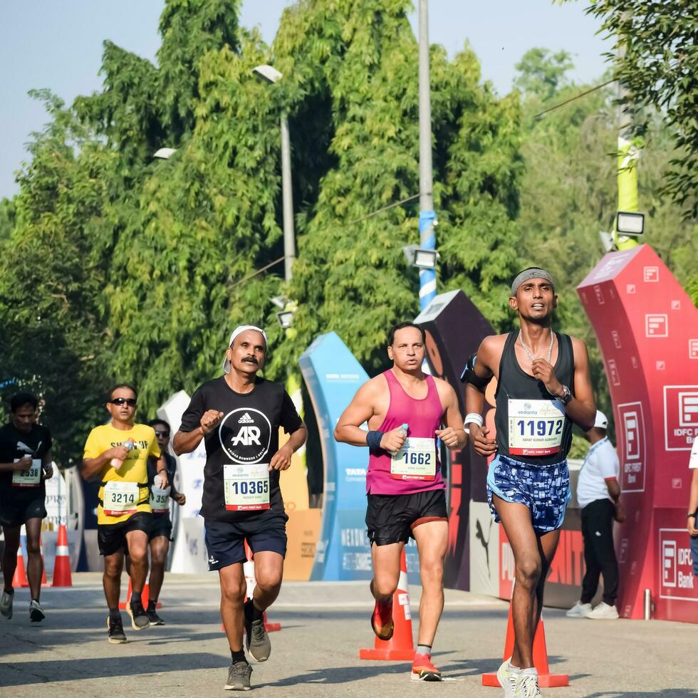 nuevo Delhi, India - junio dieciséis 2023 - vedanta Delhi medio maratón carrera después codicioso en cuales maratón Participantes acerca de a cruzar el terminar línea, Delhi medio maratón 2022 foto