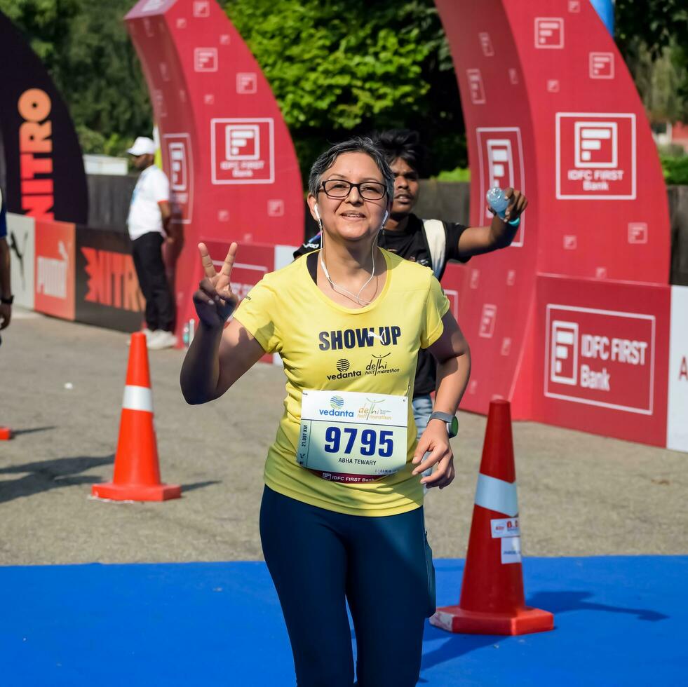 nuevo Delhi, India - julio dieciséis 2023 - vedanta Delhi medio maratón carrera después codicioso en cuales maratón Participantes acerca de a cruzar el terminar línea, Delhi medio maratón 2022 foto