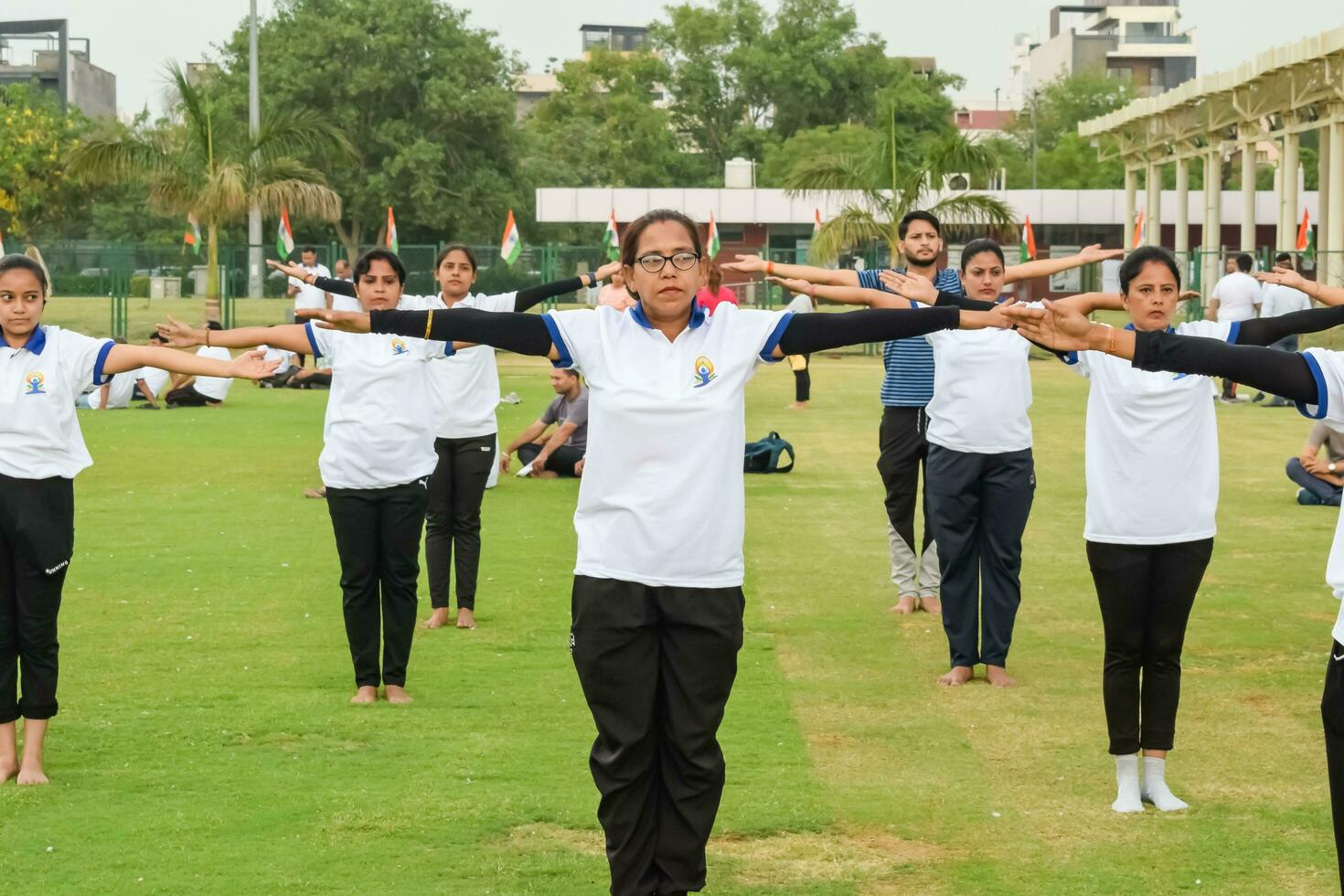 nuevo Delhi, India, junio 21, 2023 - grupo yoga ejercicio sesión para personas a yamuna Deportes complejo en Delhi en internacional yoga día, grande grupo de adultos asistiendo yoga clase en Grillo estadio foto