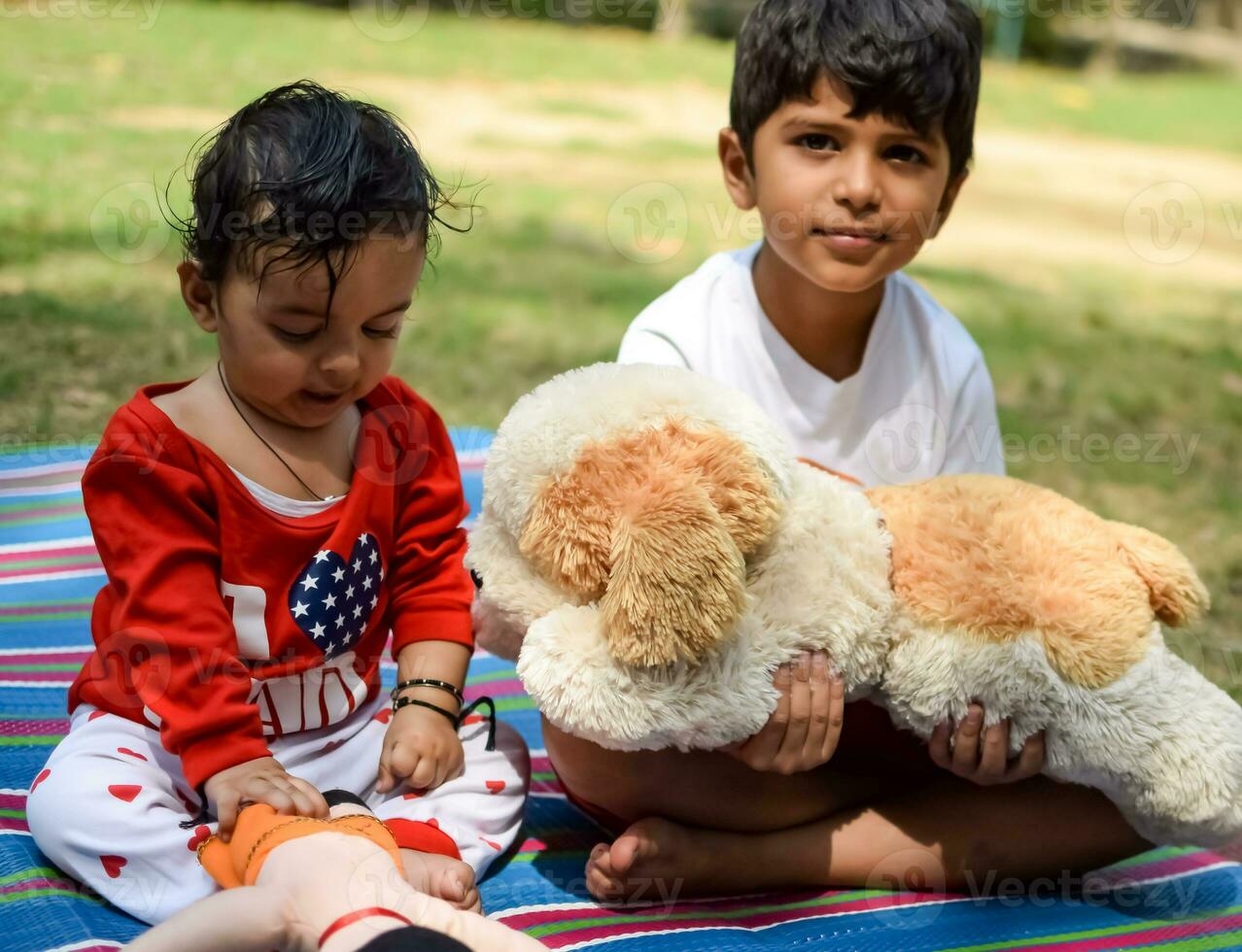 Two happy boys in society park, happy Asian brothers who are smiling happily together. Brothers play outdoors in summer, best friends. Toddler baby boy playing with his happy brother in the garden photo