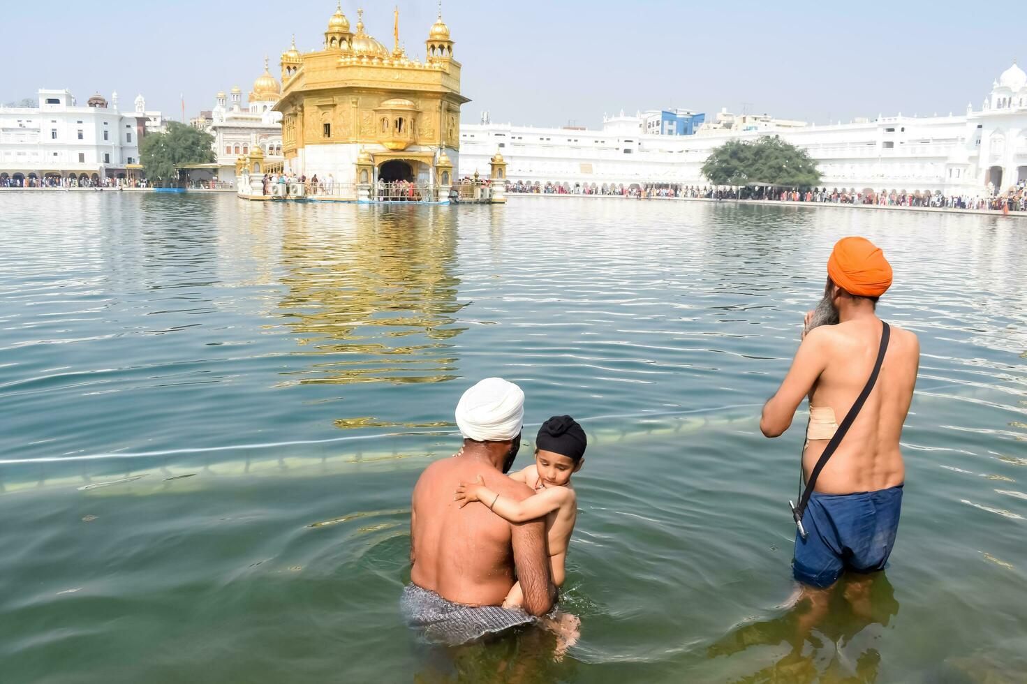 Amritsar, India - May 31 2023 - Unidentified devotees taking holy dip in sarovar at Golden Temple - Harmandir Sahib in Amritsar, Punjab, India, Famous indian sikh landmark, Golden Temple photo
