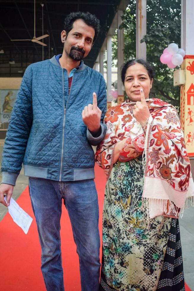 Delhi, India - July 04 2023 - Unidentified people showing their ink-marked fingers after casting votes in front of polling booth of east Delhi area for MCD local body Elections 2022 photo