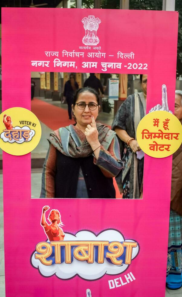 Delhi, India - July 04 2023 - Unidentified people showing their ink-marked fingers after casting votes in front of polling booth of east Delhi area for MCD local body Elections 2022 photo