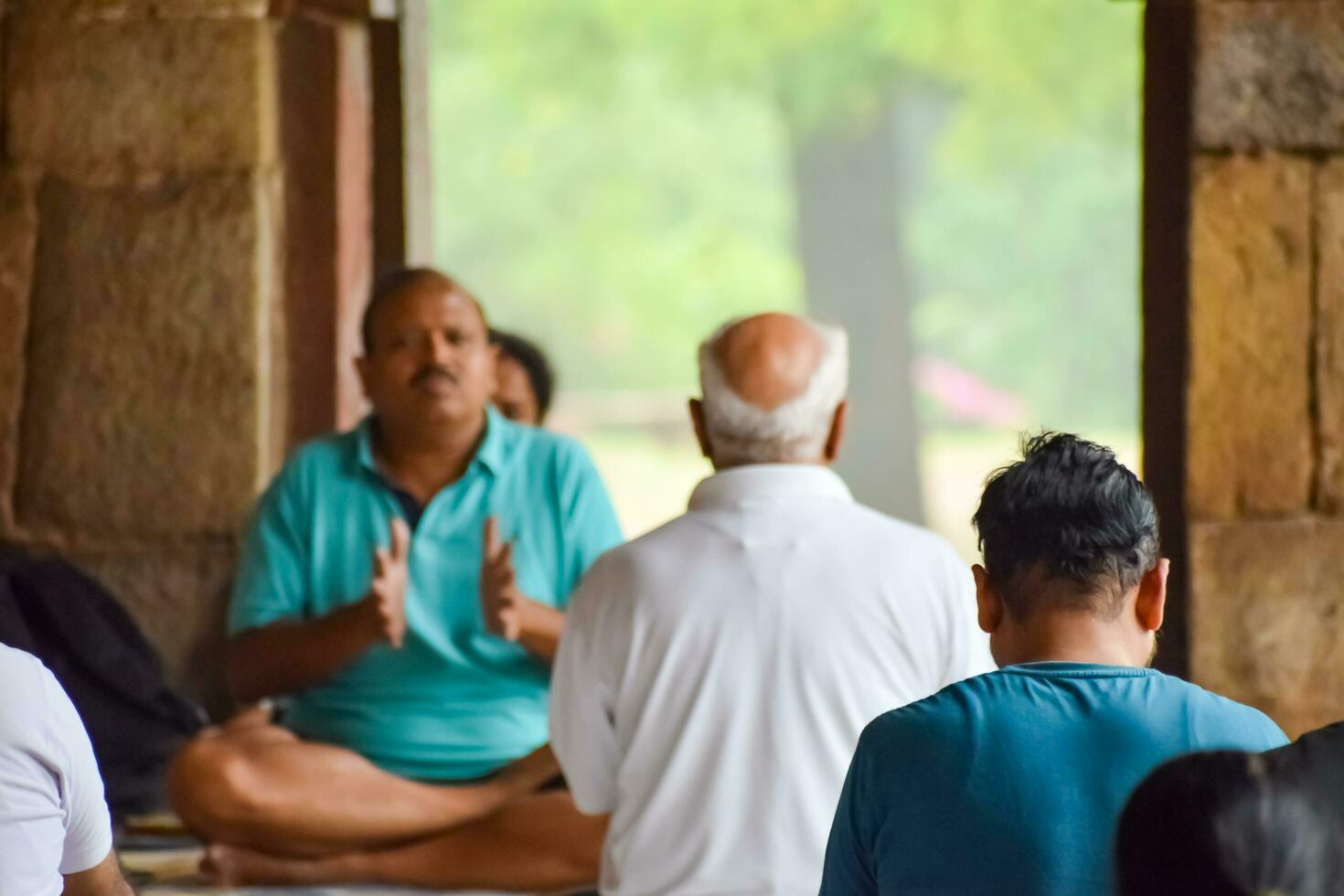 New Delhi, India, May 31 2023 - Group Yoga exercise class for people of different age in Lodhi Garden, International Yoga Day, Big group of adults attending a yoga class in park photo