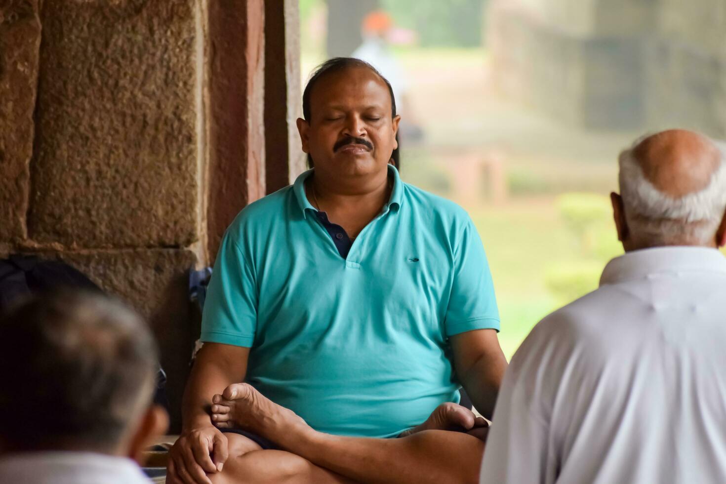 New Delhi, India, May 31 2023 - Group Yoga exercise class for people of different age in Lodhi Garden, International Yoga Day, Big group of adults attending a yoga class in park photo