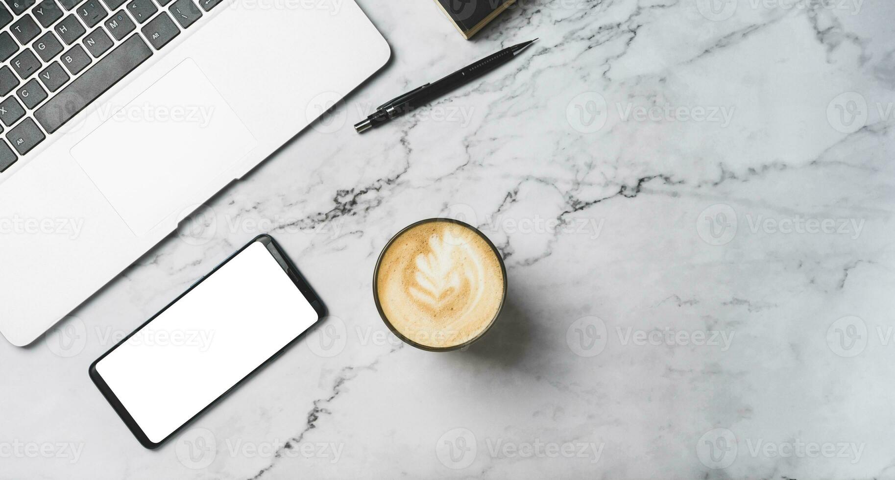 top view of mobile smart phone black white mock up blank copy space for use. on desk with laptop and coffee ,pencil on grey marble. photo