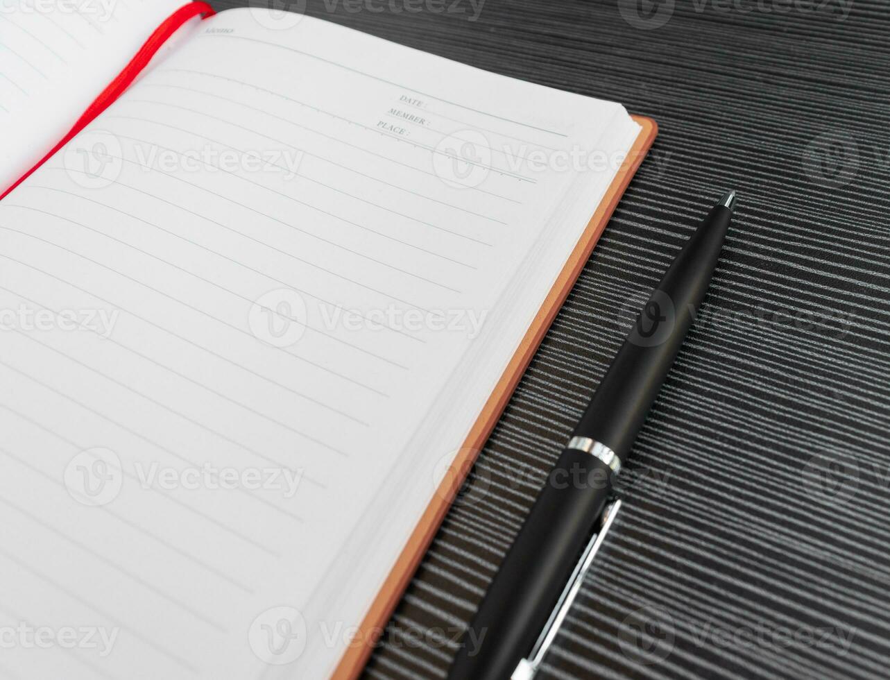 A pen, book and sunglasses placed on a textured table, after some edits. photo