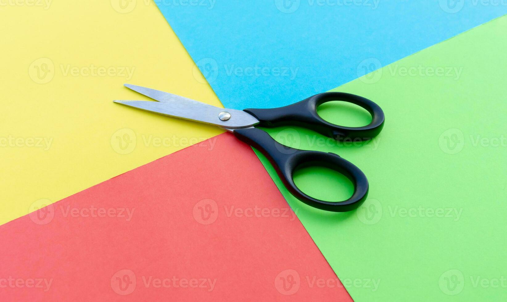 Scissors placed on colored papers, after some edits. photo