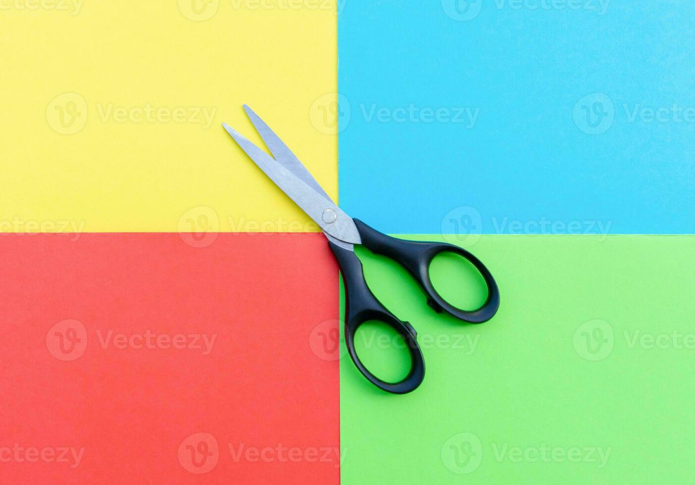 Scissors placed on colored papers, after some edits. photo