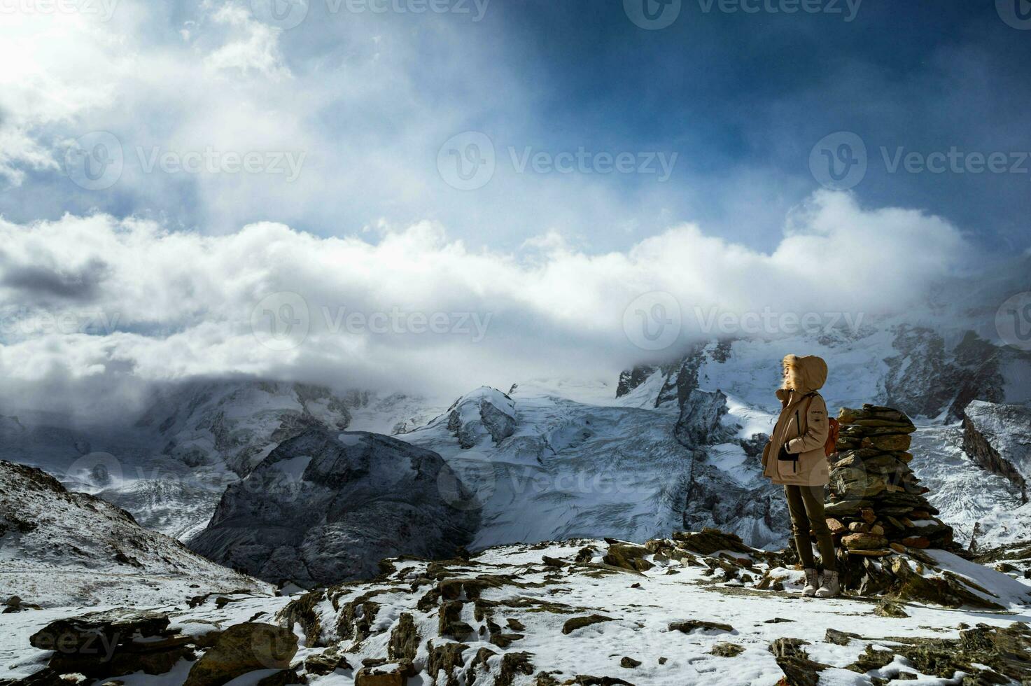 An impressive scene of a man in winter coat admiring the beauty and majesty of the Matterhorn, one of Switzerland's highest peaks photo