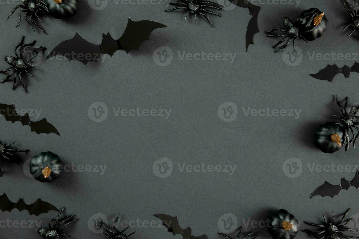 Happy halloween flat lay composition with black pumpkins, spiders and bats on dark background. Holiday concept. Top view. Copy space. photo