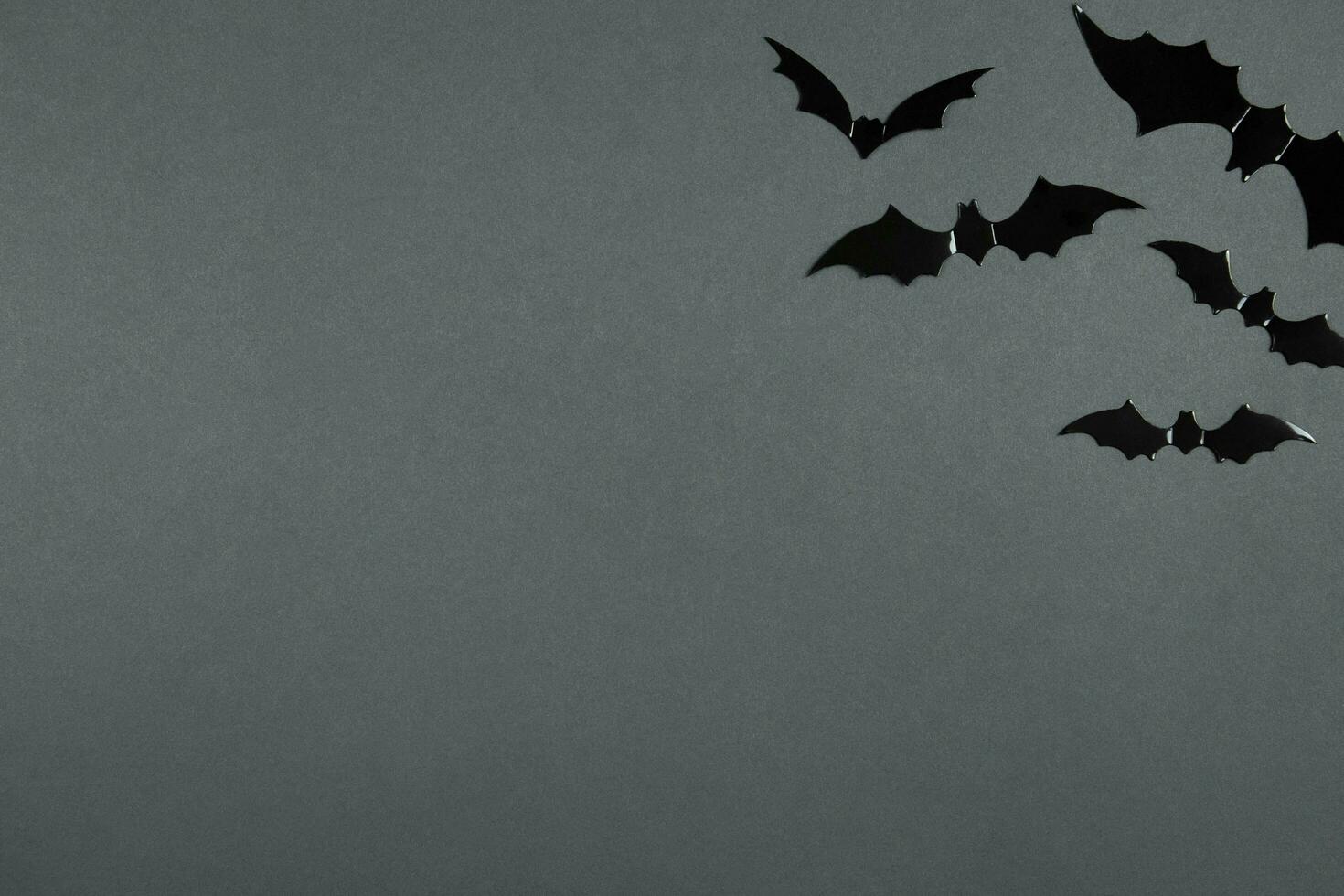 Happy halloween flat lay composition with black bats on dark background. Holiday concept. Top view. Copy space. photo