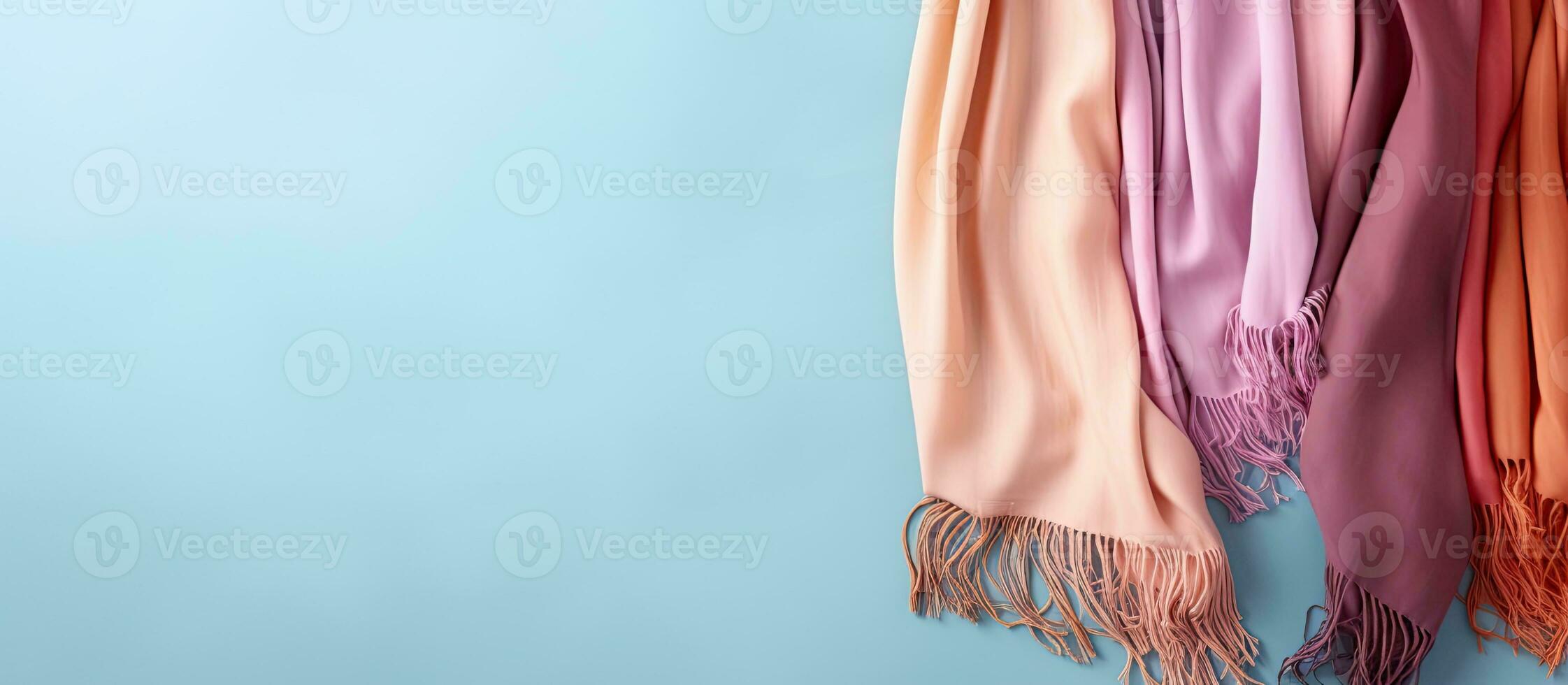 Photo of a vibrant multicolored scarf hanging on a blue wall with plenty of copy space with copy space