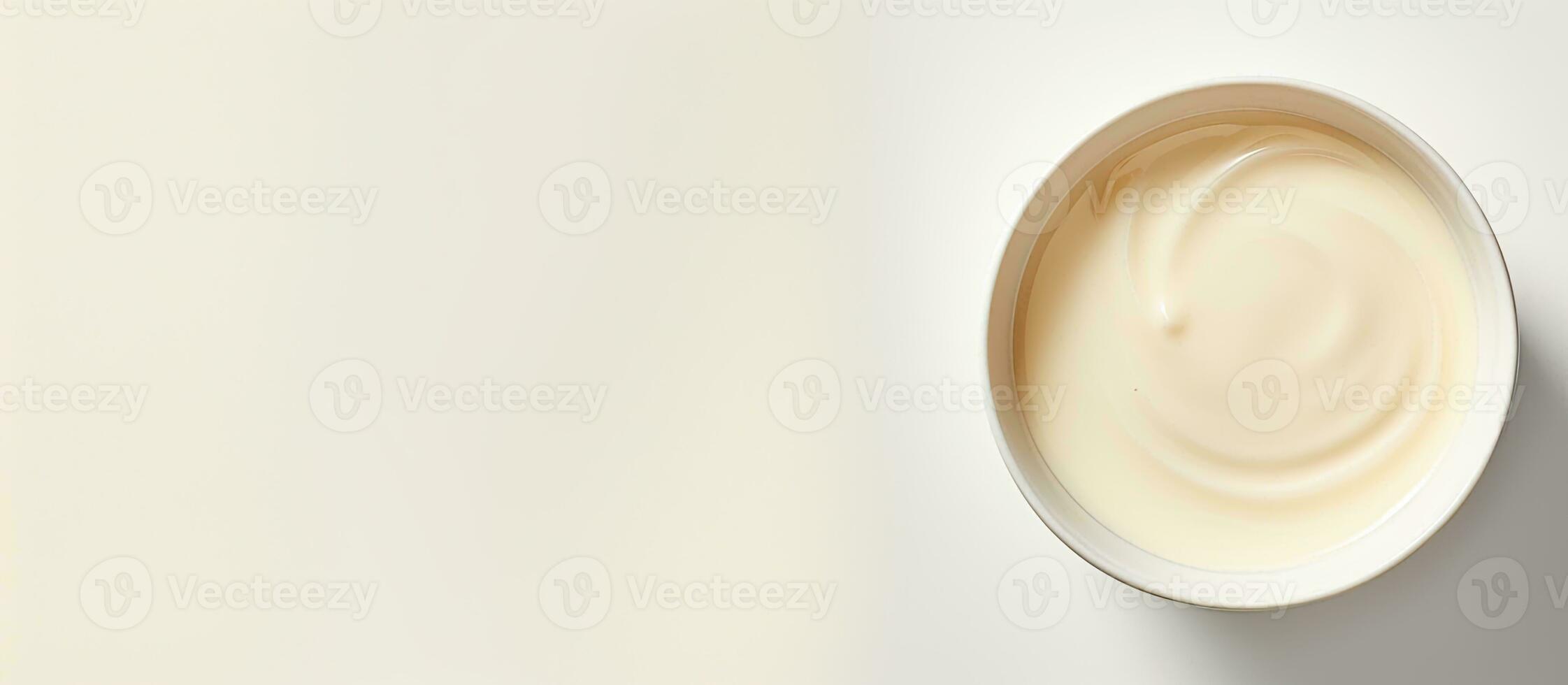 Photo of a bowl of creamy yogurt on a clean white surface with copy space