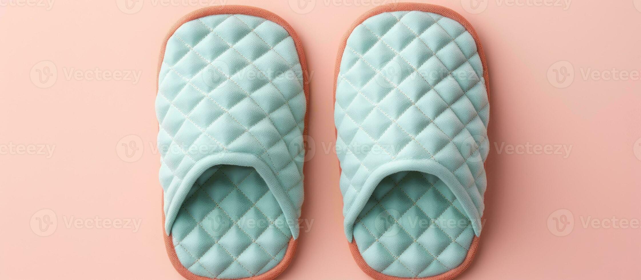Photo of a pair of blue slippers on a pink background with plenty of space for your own text or design with copy space