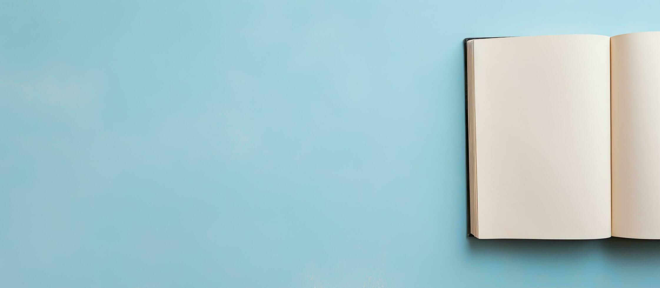 Photo of an open book on a vibrant blue wall, creating a minimalistic and serene composition with copy space