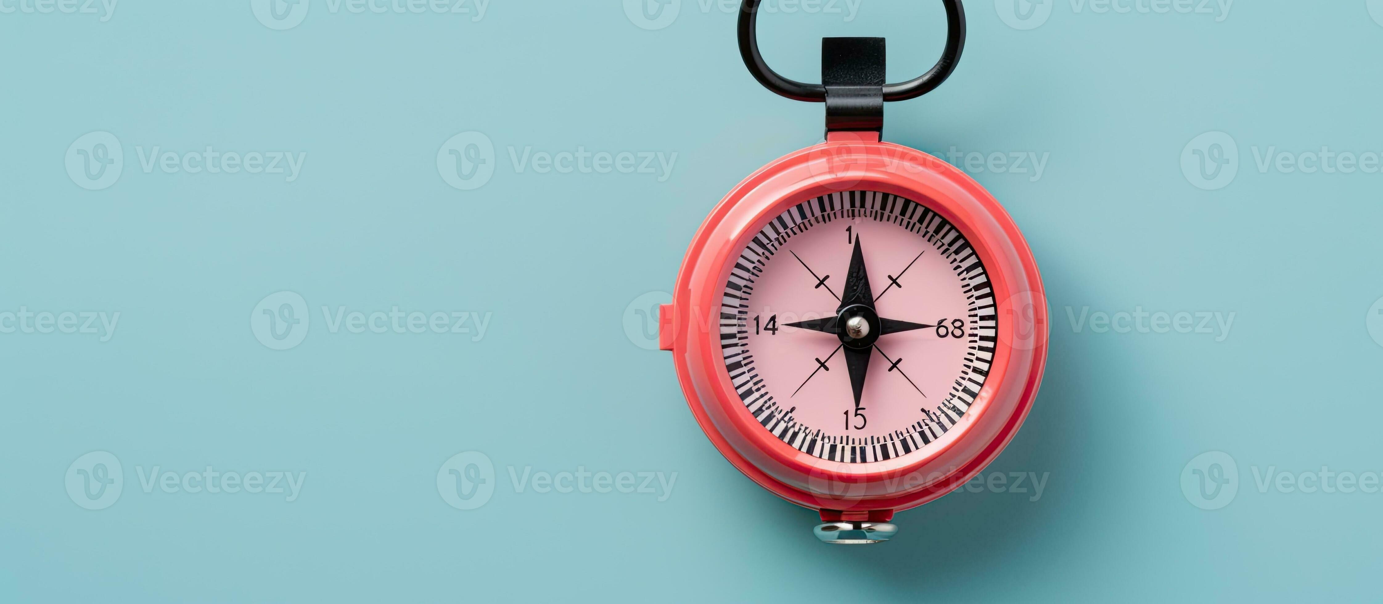 Photo of a red and black compass on a blue background with plenty of