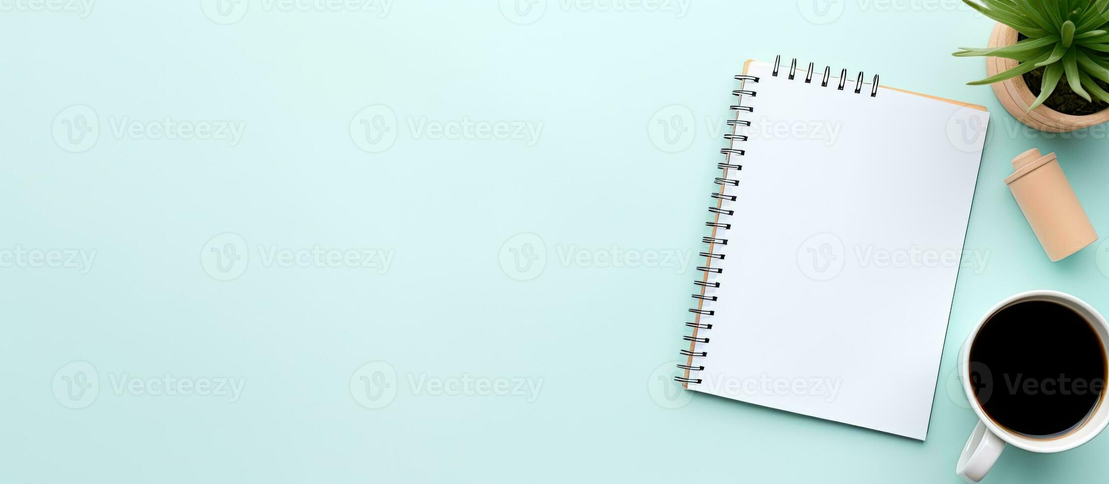 Photo of a coffee cup, notepad, and plant on a table with plenty of space for your own message with copy space