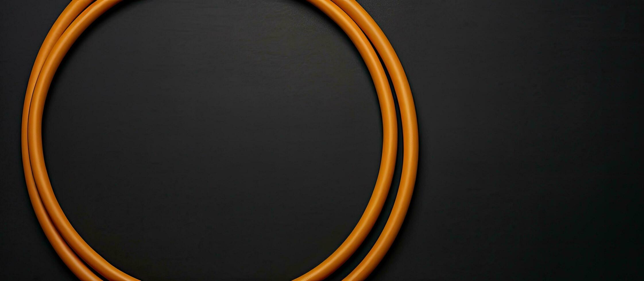 Photo of an orange cord on a black surface with empty space for text or other elements with copy space
