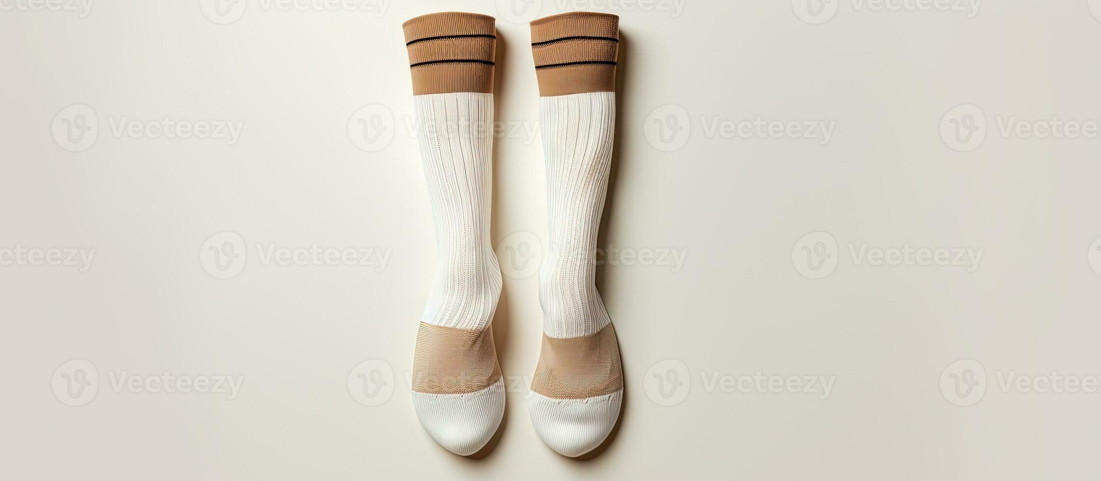 Photo of a pair of socks hanging on a wall, with white and brown colors contrasting against the background with copy space