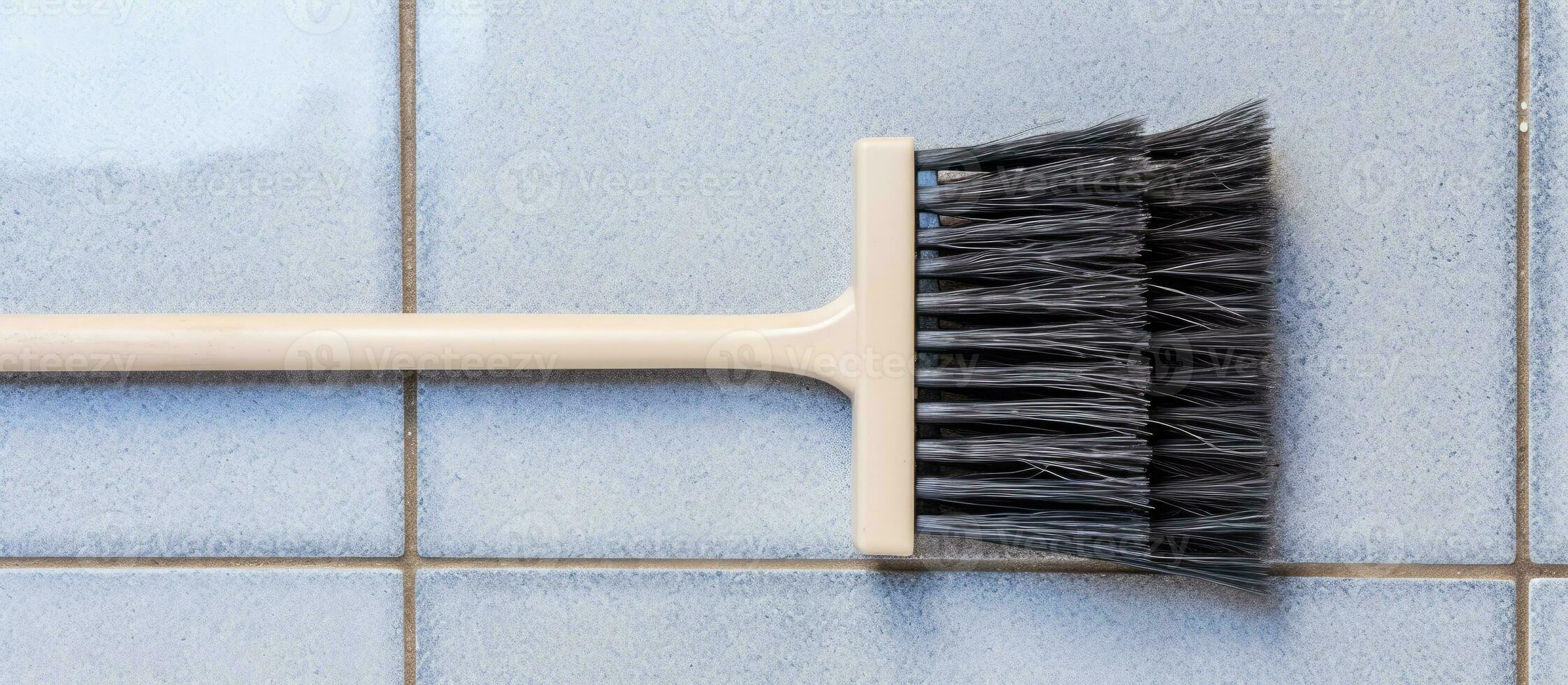 Photo of a white brush against a vibrant blue tiled wall with empty space for copy with copy space