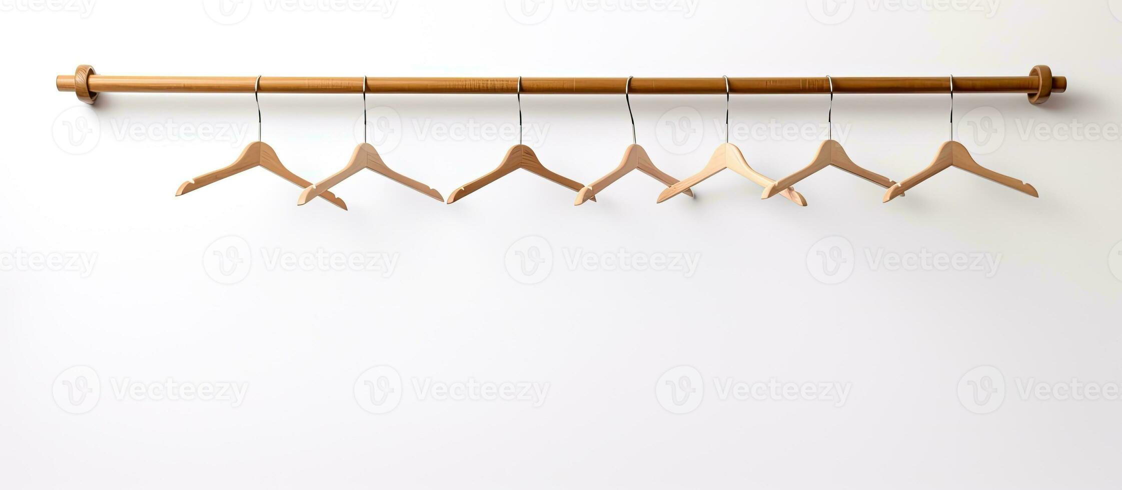 Photo of a minimalist wooden coat rack hanging on a white wall with plenty of space for personalization with copy space