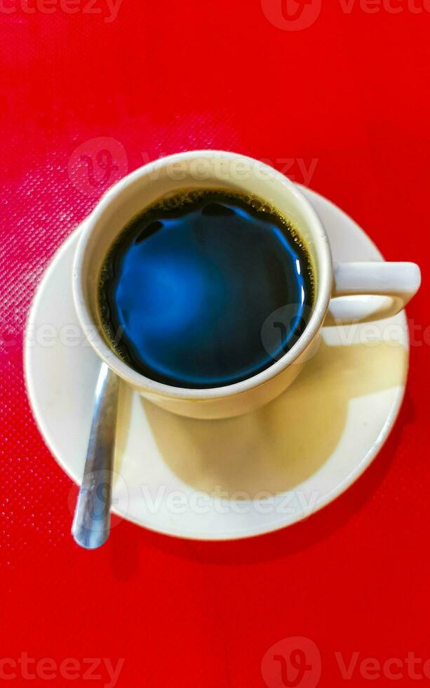 Cup of americano black coffee red background Mexico. photo