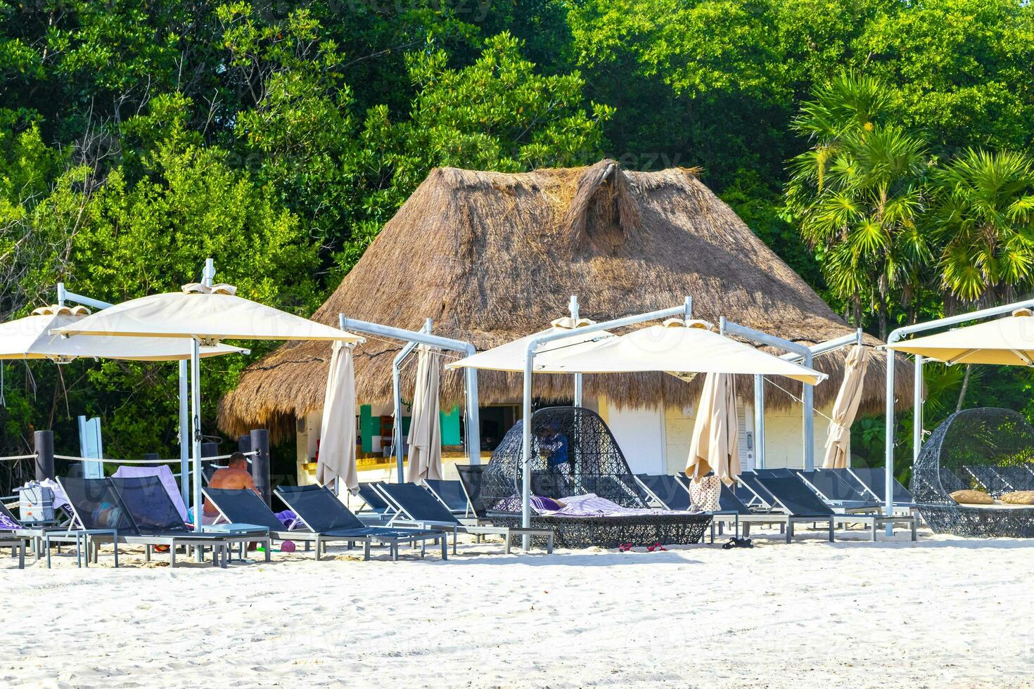 Palms parasols sun loungers beach resort Playa del Carmen Mexico. photo