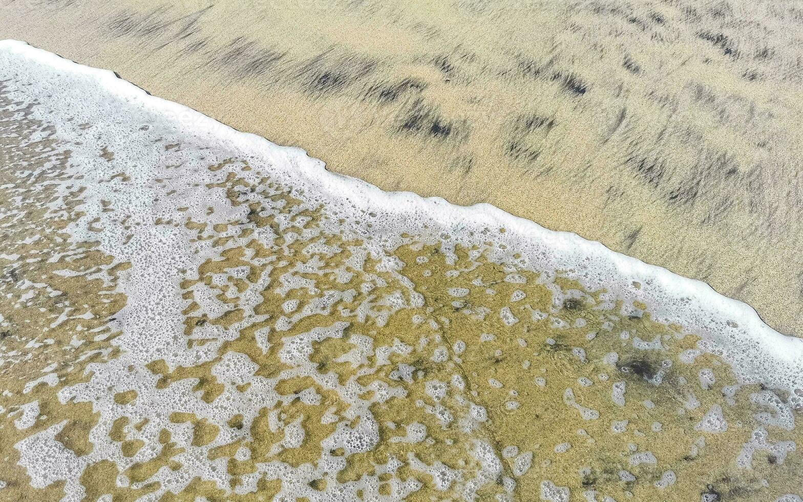 Wet beach sand water and waves texture and pattern in Mexico. photo