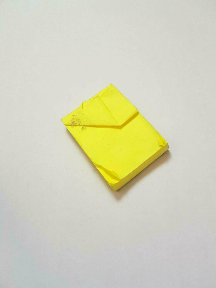 Isolated white photo of a sticky note in dirty and worn condition.