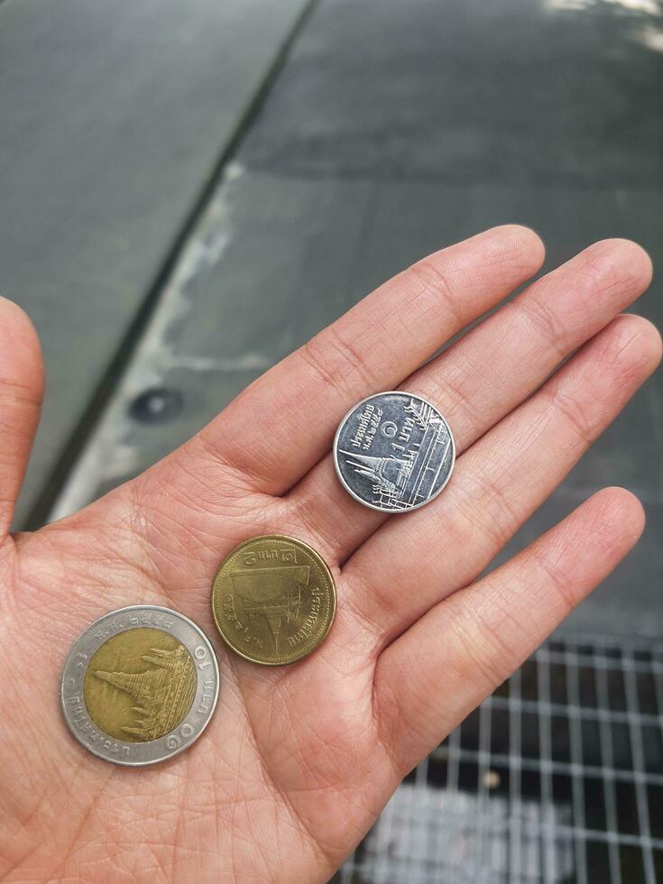 a hand holding baht coin photo